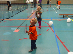 2 kleine kindjes aan het badmintonnen in een sporthal