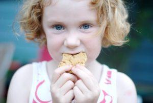 Een meisje eet een koekje