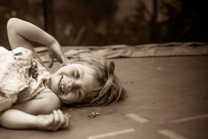 een meisje ligt lachend op een trampoline