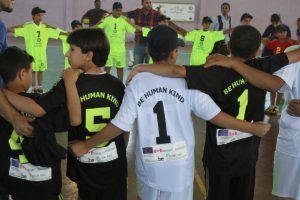 Syrische, Palestijnse en Jordaanse jongeren staan in groepen bij elkaar voor de voetbalwedstrijd