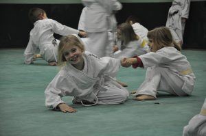 2 meisjes in judo pak die hard aan elkaars arm trekken