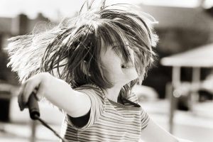 Een kindje is vrolijk aan het touwtje springen