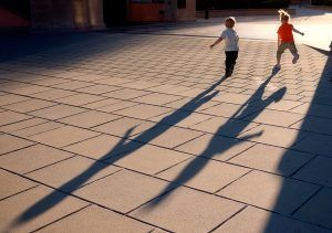 2 kindjes lopen over een leeg plein