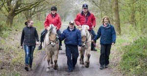 Zorgmedewerkers begeleiden 2 cliënten tijdens een tochtje op een pony