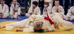 junior wedstrijd judoka's. een twee gevecht met daar omheen een kring van zittende jeugdspelers