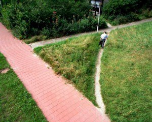 Een man loopt over een pad dat ontstaan is doordat mensen door het gras heen een kortere route pakken