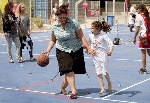 Volwassene en kind spelen basketbal op een Richard Kraijcek speelveldje