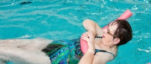 Vrouw drijft op haar rug in het zwembad