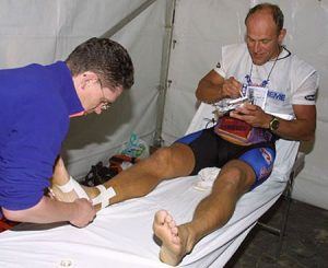 Een sporter wordt verzorgd aan een voetblessure