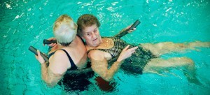2 oudere vrouwen in het zwembad bezig met een oefening