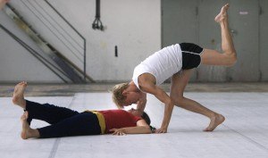2 volwassenen doen een oefening waarbij sport en dans wordt gecombineerd