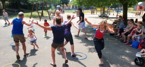 Ouders en kinderen spelen een spel op een schoolplein met hoepels op de grond