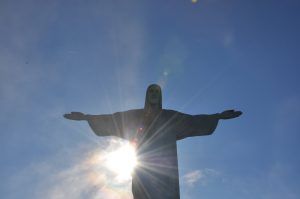 Het beeld Christus de Verlosser in Rio waar de zon fel achter schijnt