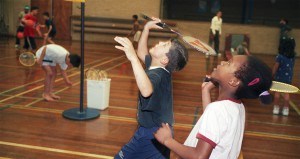 Kinderen aan het badmintonnen in de zaal
