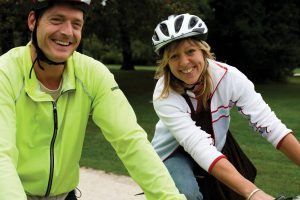Een man en vrouw die op een fiets zitten en lachen