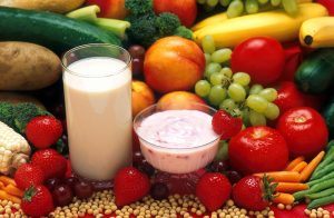 Een schaaltje kwark en een glas melk omringd door groente en fruit