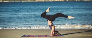 vrouw doet yoga oefening op het strand