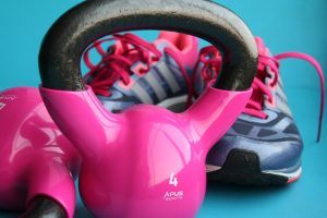 een roze kettlebell en sportschoenen