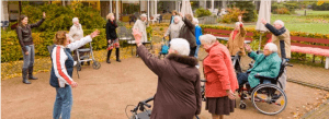 ouderen buiten oefeningen aan het doen met begeleiding
