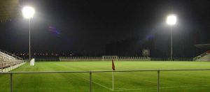 een leeg voetbalveld waar de lichtmasten met ledverlichting aanstaan