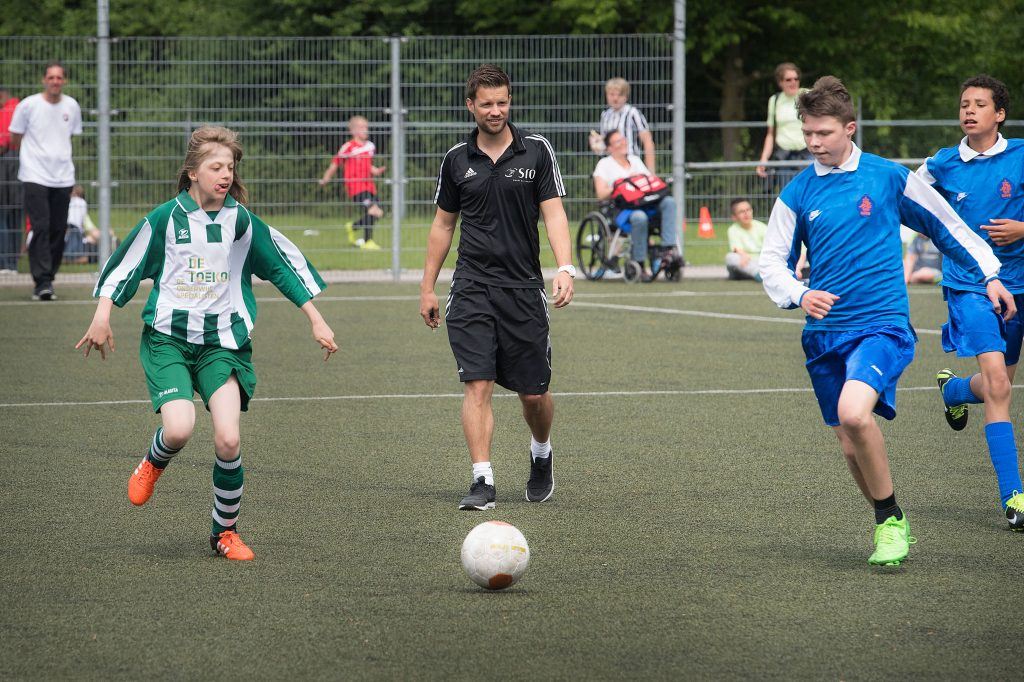 kinderen aan het voetbalen op het voetbalveld,