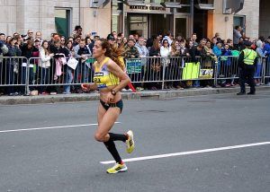 een vrouw aan het hardlopen tijdens de marathon van Boston