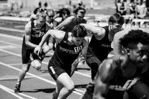 zwart wit foto van atleten die een sprintje trekken