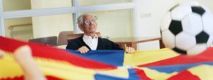 Een oudere man wappert met een laken:beweegactiviteit voor kwetsbare ouderen