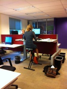 Medewerkster achter een bureau op een bureaufiets