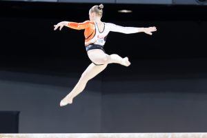 Sanne Wevers maakt tijdens een sprong in de lucht een spreidsprong