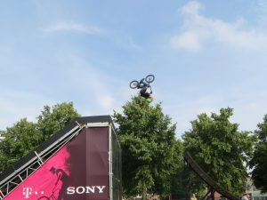 een deelnemer aan een urban sport evenement maakt een salto hoog in de lucht met zijn fiets