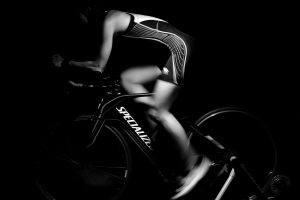 een zwart wit foto van een atleet op een sportfiets