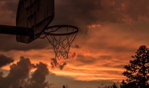een basketbal basket met op de achtergrond een mooi gekleurde lucht door ondergaande zon