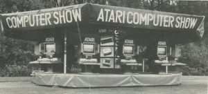 een oude foto met een kraam waar atari spelcomputers zijn uitgestald