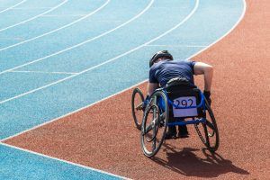 een sporter in een rolstoel aan de rand van een atletiekbaan