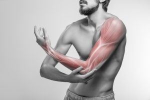 een zwart wit foto van een man die spierpijn heeft in zijn arm en dat wordt uitgebeeld doordat op zijn arm spieren zijn ingetekend