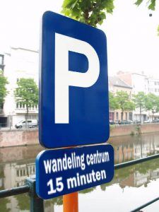 verkeersbord om een parkeergelegenheid aan te geven en waaronder staat vermeld dat het centrum 15 minuten lopen is