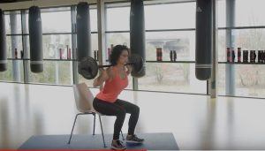 vrouw op een stoel in een fitnessruimte oefeningen aan het doen