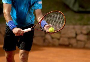 een tennisspeler heeft een tennisracket en bal vast en staat klaar om te serveren