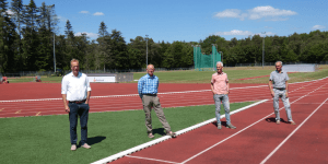 vier mannen poseren voor de camera op een atletiek vereniging