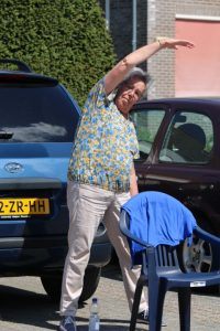 Ouderen bewegen op de parkeerplaats van een zorginstelling, op anderhalve meter afstand