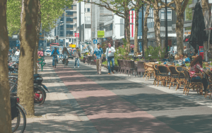 een straat in Rotterdam met terras, fietspad en loopstraat