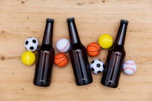 flesjes bier met voetballen, tennisballen en basketballen