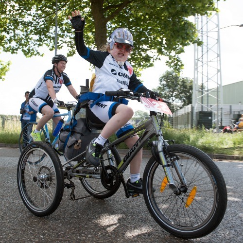 Een meisje op een sportfiets driewieler tijdens de Special Olympics