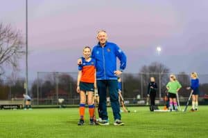 Foto van Bob Roos, staand poserend op het hockeyveld tijdens een training